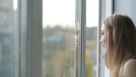 Person breathing calmly by a window in soft morning light